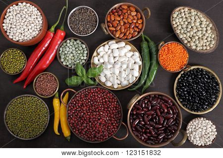 Beans peas and lentils in metal bowls.