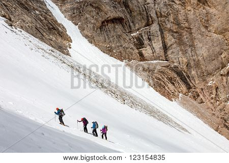 Members of Alpine Expedition Hardly Walking Up on Steep Snowfield Using Ice Climbing and Hiking Gear