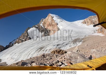 Glacier and High Mountain Peak Taken throw Window Entrance Door of Alpine Tent Blue Sky Rocky Moraine