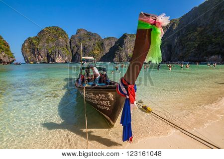 Maya Bay, Phi Phi Leh, Thailand - December 31, 2015:  a long tail boat, typical traditional wooden boat, near the shore of Maya Bay lagoon of famous movie The Beach with Leonardo Di Caprio.