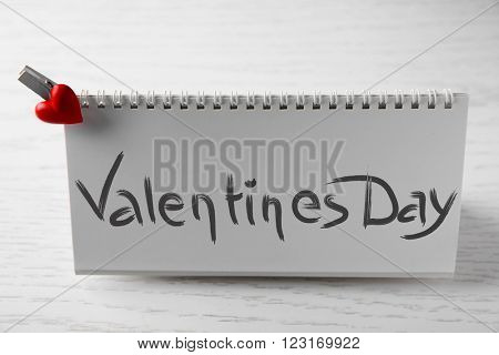 Blank present card with small heart on wooden background