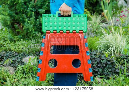 Colored Folding stool hanging in the hand