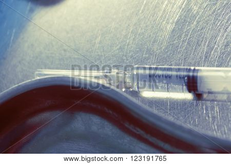 Syringe with a drug on a dirty metal surface.
** Note: Shallow depth of field