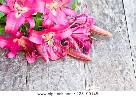 pink lily Robina flowers bouquet on rustic wooden table