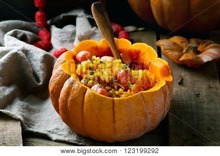 stew from pumpkin with salami sausages in the whole pumpkin on rural background .selective focus