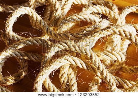 Vintage toned image of hank large ship's rope on the background of a brown wooden table. Hank of twine.