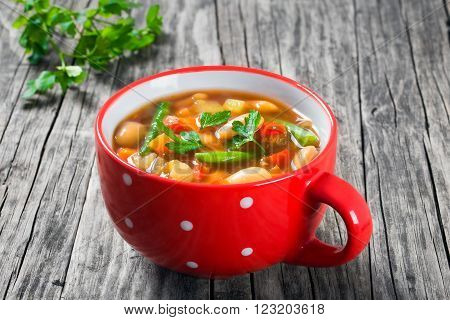 Minestrone vegetable soup with beans cauliflower tomatoes close-up top view