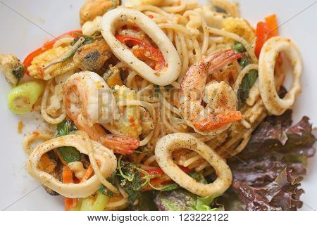 stir-fried spicy spaghetti with seafood. thai style stir-fried spicy spaghetti with seafood. stir-fried spicy pasta with seafood.