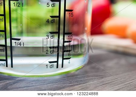 200Ml / 2Dl Of Water In A Measuring Cup On A Kitchen Counter With Vegetables
