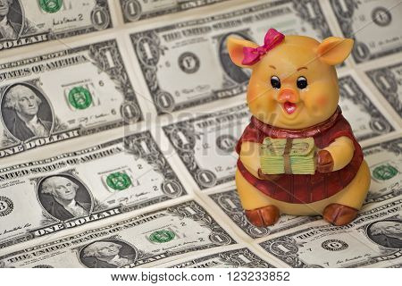 Piggy bank with money from ceramics in the notes on the background of the feet.