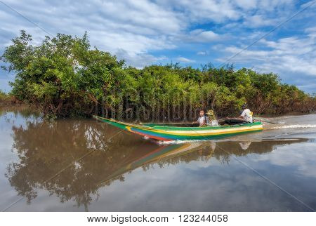 SIEM REAP, CAMBODIA DEC. 16: Cambodian people live on Tonle Sap Lake in Siem Reap, Cambodia on December 16, 2011. Family traveling by boat along the river Siem Reap.