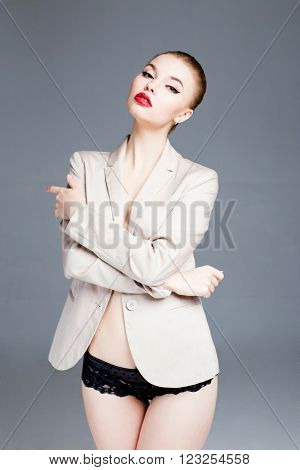 Sexy seductive brunette female fashion model in jaket posing in studio