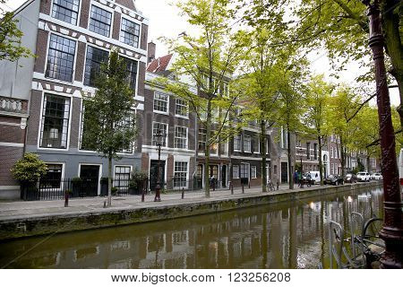 AMSTERDAM; THE NETHERLANDS - AUGUST 18; 2015: View on beautiful street Oudezijds Achterburgwal, street life, canal and tourists. Amsterdam is capital of the Netherlands on August 18; 2015.