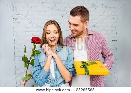 Surprised young woman receiving gifts from her husband