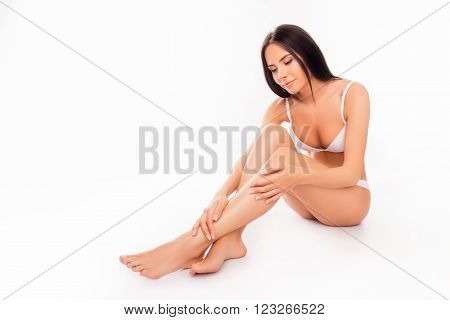 Pretty Woman In Lingerie Sitting And  Touching Her Smooth Legs