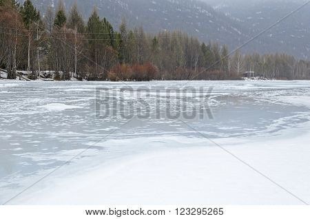 Irkutsk Region, Russia -March,20 2016: Icebound river on a cloudy spring day in the village. Kochergat Irkutsk Region Russia