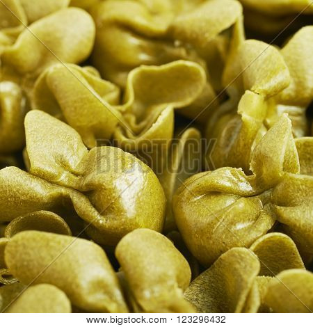 Surface covered with sacchettoni green stuffed sacchetti pasta, close-up fragment crop as a background composition