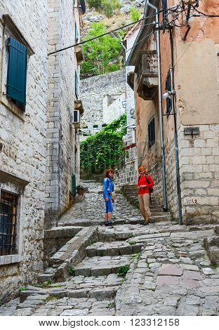 KOTOR MONTENEGRO - SEPTEMBER 21 2015: Unidentified tourists climb along a narrow street of the Old town to the fortress Kotor Montenegro