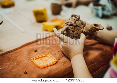 children's hands sculpts clay crafts pottery school
