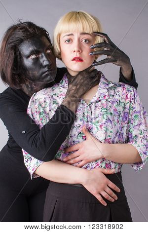 two conceptual bright girls personify the good and evil in suits