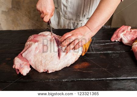 Slicing raw pork meat on piece in farm market.  Butcher slicing raw pork meat in local market. Top view