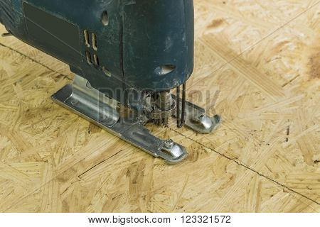 Old electricsaw cutting a sheet of OSB