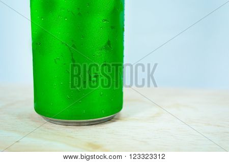 Drink chilled cans green and with water drops attached. There is a wood background focus water drops.