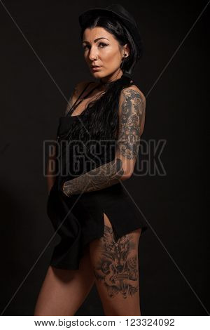 Beautiful sexy glamorous girl with tattoos on black background