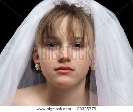 Teen girl - the bride. Portrait of a young, weeping bride. The concept of early marriages with underage children