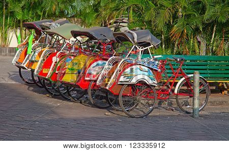 YOGYAKARTA - AUGUST 03: Traditional rikshaw transport on streets of Yogyakarta, Java, Indonesia on August 03, 2010. Bicycle rikshaw remains popular means of transport in many Indonesian cities.