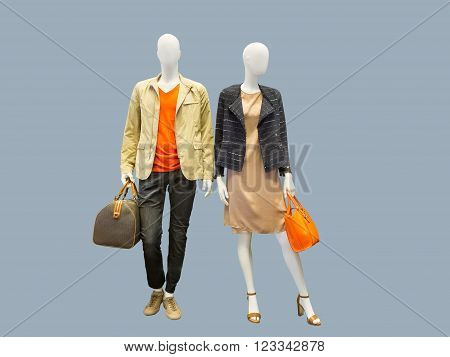 Two mannequins male and female dressed in casual clothes. Isolated on grey background