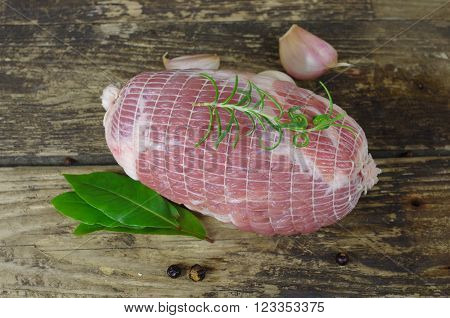 raw ham with rosemary and laurel on board
