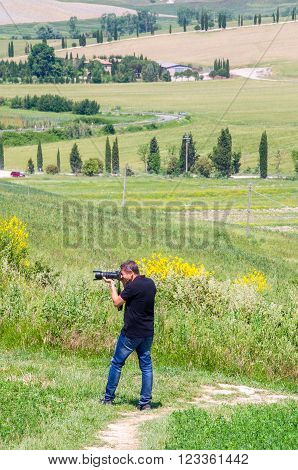 Siena Italy May 31 2015 - Landscape photographer at work on tuscany hills