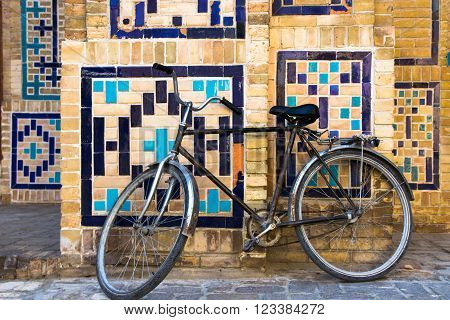 Old bicycle against the wall at ancient building on old street of Bukhara Uzbekistan