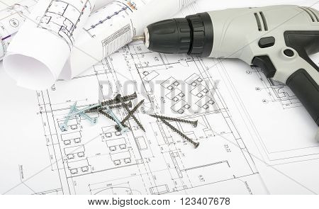 Architecture plan and rolls of blueprints with cabel and electric screwdriver. Building concept