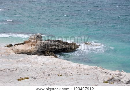 Turquoise Indian Ocean waters with limestone formations at Foul Bay Beach in Hamelin Bay, Western Australia.
