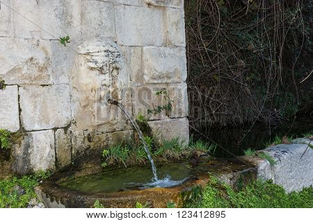 Fountain with sculpture on the wall. Typical of the Sicilian countryside. Typical of the province of Ragusa places of Montalbano. Holiday sights and cultural tourism.