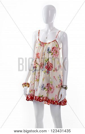 Sarafan with accessories on mannequin. Female mannequin wearing floral sarafan. Flax sarafan with classic accessories. Sarafan with jewelry and watch.