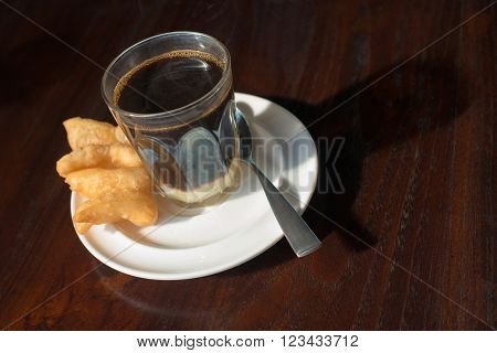 Thai tradition hot coffee with sweetened condensed milk in old style cup served with deep fried dough or 