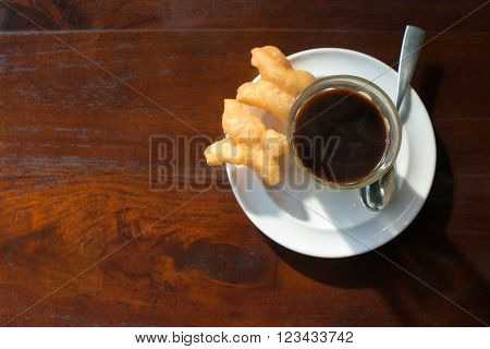 Thai tradition hot coffee with sweetened condensed milk in old style cup served with deep fried dough or 