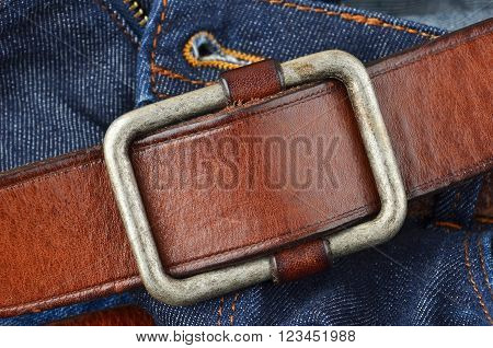 Blue jeans with natural leather belt close up