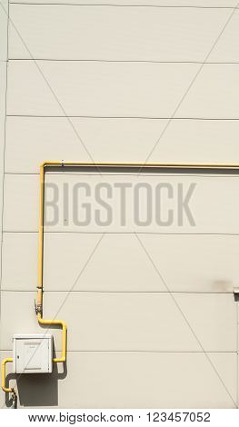 Yelow Pipes And Gas Meter On Gray Wall
