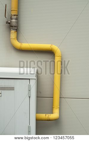 Yelow Pipes And Gas Meter On Gray Wall