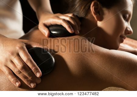 Massage with hot basalt stones. Beautiful deep charming light.
** Note: Shallow depth of field