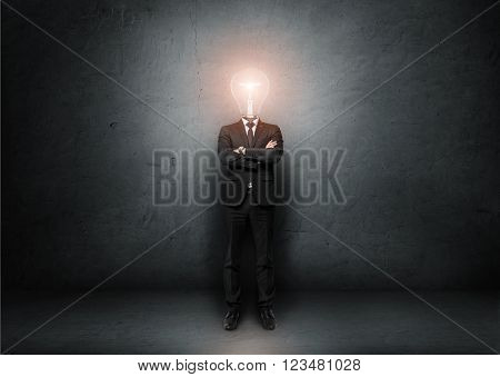 Businessman with light bulb instead of head on a concrete room. Concept of idea.