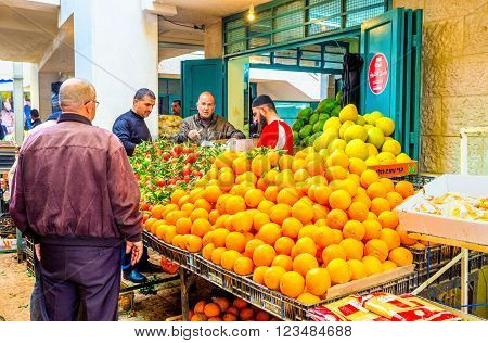 BETHLEHEM PALESTINE - FEBRUARY 18 2016: The merchant sells fruits to clients in Bethlehem market on February 18 in Bethlehem.