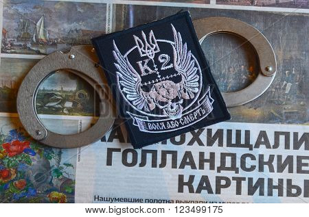 Kiev,Ukraine.FEB 20.ILLUSTRATIVE EDITORIAL.Chevron Ukrainian nazionalist battalion.Background - newspaper about West Frisian Museum stolen art . February 20,2016 in Kiev, Ukraine