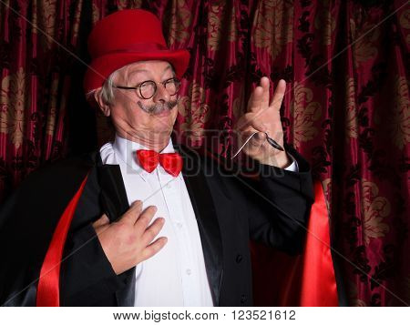 Senior illusionist on stage bending a spoon