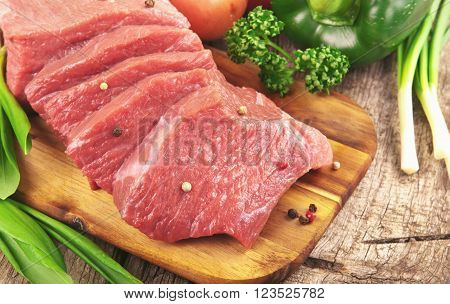 Fresh raw beef with vegetables on cutting board top view