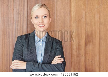 Portrait of a confident young businesswoman with wooden background